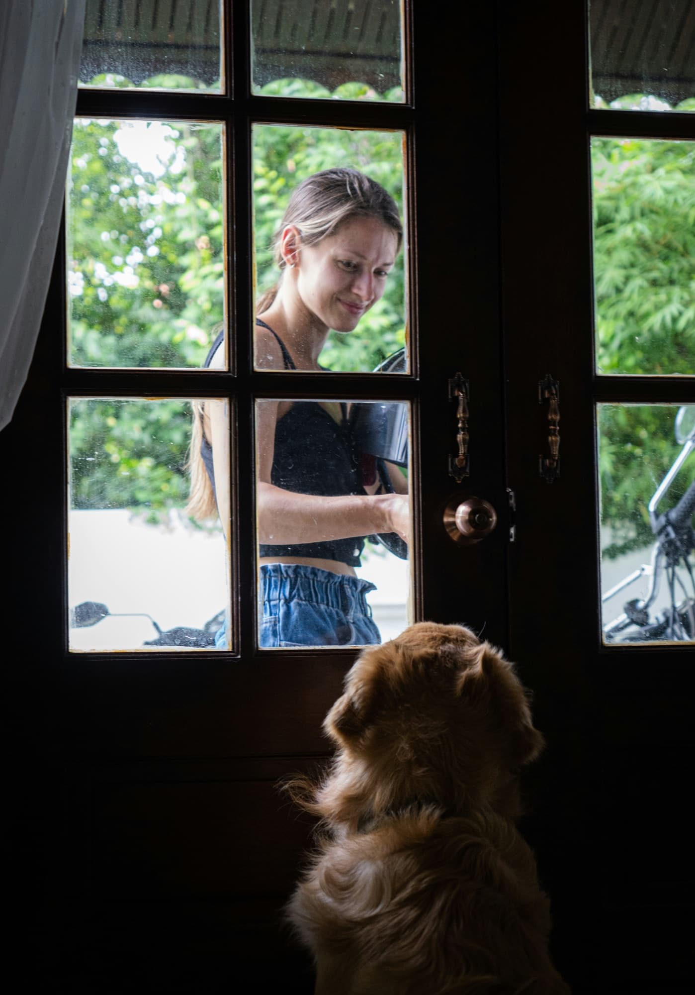 A sitter arriving at a client's front door, greeted by their dog